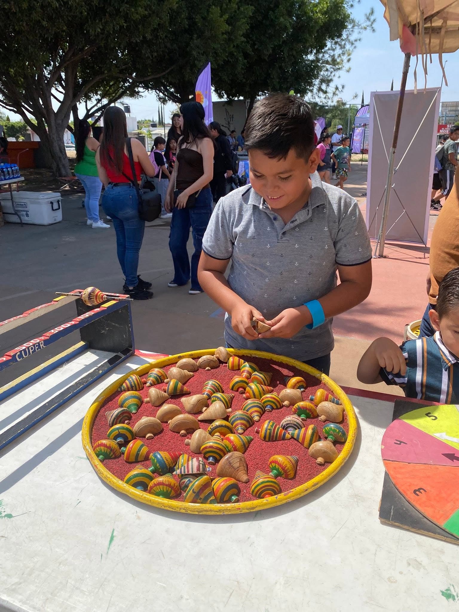 Niño eligiendo un trompo tradicional en una actividad